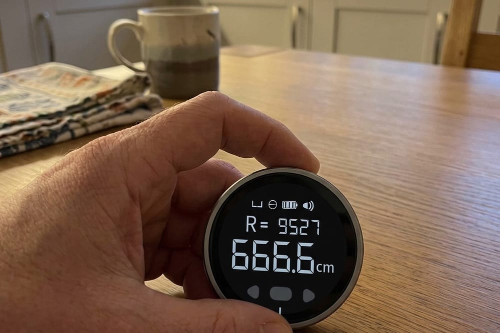 The backlit LCD screen showing a measurement in inches